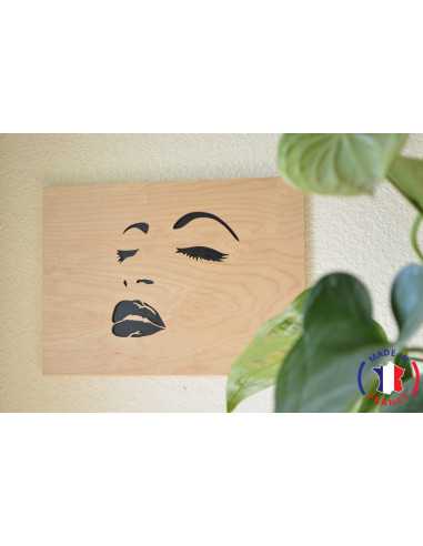 Painting of a woman's face chantourné in birch.